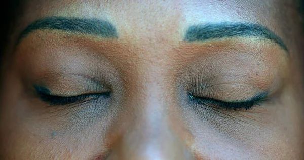 Black woman eyes closed, person opening eye macro close-up awakening