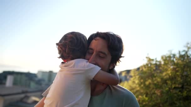 小男孩面颊上吻着父亲 站在夕阳西下 父亲抱着孩子 黄金时段与孩子美好的父爱时刻 — 图库视频影像