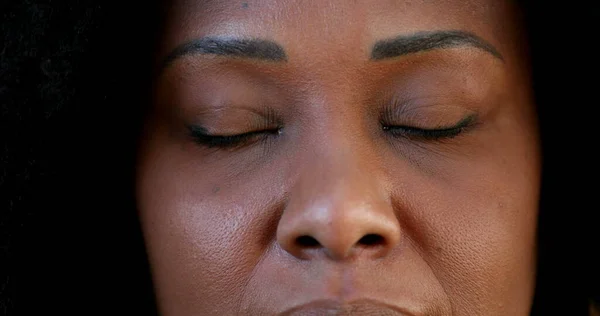 Woman closing eyes, close-up face eye closed, African ethnicity
