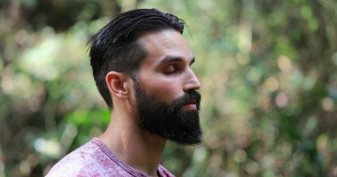 Dışarıda meditasyon yapan yakışıklı bir adam. Yogi insanı meditasyonda.