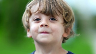 Sevimli çocuk portresi kameraya gülümsüyor. Küçük çocuk, yakından gülümsüyor.