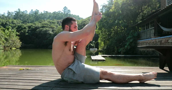 Man stretching leg outdoors, Yoga man exercising at deck