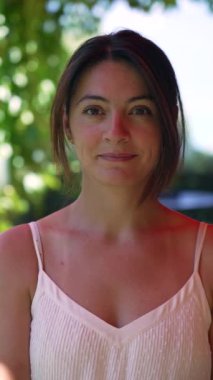 30 'lu yaşlarda, kameraya bakan bir kadının portresi. Dikey Videoda gülümseyen bir kadının yüzünü kapat.
