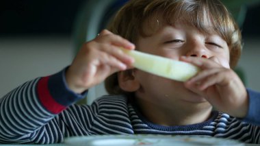 Yeşil karpuz meyvesi yiyen çocuk sağlıklı abur cubur yiyor.