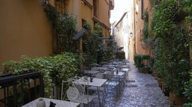 Avrupa 'nın eski caddesinde kaldırım taşları üzerinde sandalyeler ve masalar var. İtalyan sokak arasında kimse yok.