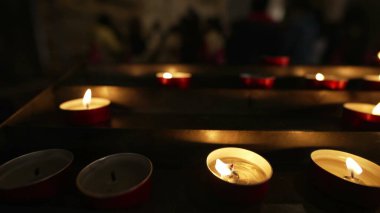 Katolik Katedrali 'nin içinde mum ışıkları ağır çekimde dua ederken yanıyor. Umut ve İnanç kavramı