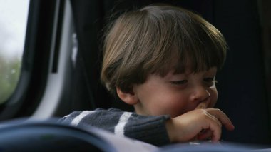 Yolcu çocuk trenle seyahat ederken kitaptaki resimlere bakıyor. Yakından çocuk yüzü.