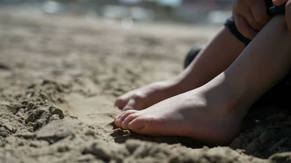Child foot on sand outside. Closeup kid barefoot feet at beach feeling nature
