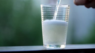 Yavaş çekimde canlandırıcı içecek bardağa dökülüyor. Köpüklü içecek servisini kapat.