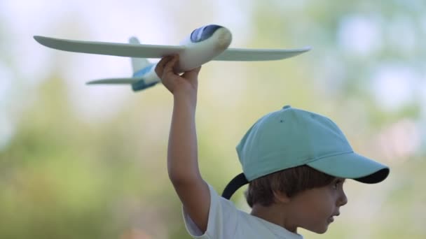 小さな男の子が泡飛行機のおもちゃを外に投げます 飛行機のグライダーで遊ぶ子供 子供は屋外で楽しんでいる — ストック動画