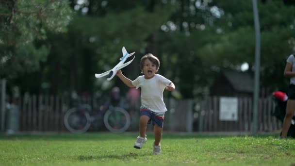 Jovem Correndo Com Brinquedo Avião Parque Criança Despreocupada Jogando Avião — Vídeo de Stock