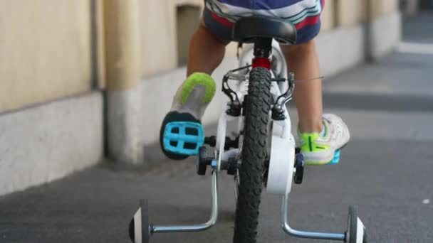 Baksidan Barn Rider Cykel Med Stödjande Hjul Utanför Stadens Gata — Stockvideo