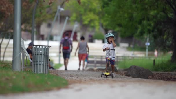 Beztroski Skuter Dziecięcy Parku Jeden Chłopak Kasku Jeździ Hulajnodze Zewnątrz — Wideo stockowe