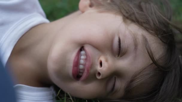 Niño Relajado Con Los Ojos Cerrados Acostado Hierba Parque Primer — Vídeos de Stock