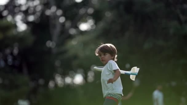 소년은 공원에서 비행기 장난감을 던졌습니다 밖에서 비행기 글라이더를 가지고 노는아이 — 비디오