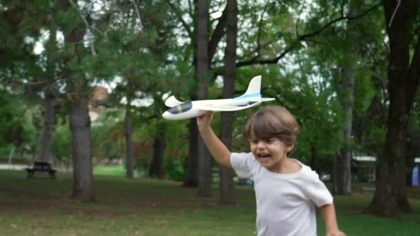 Een Gelukkig Kind Dat Naar Buiten Rent Met Een Vliegtuigzweefvliegtuig — Stockvideo