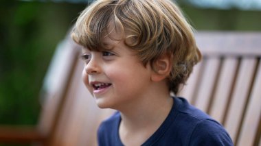 Küçük mutlu bir çocuğun portresi. Gülen ve gülümseyen küçük çocuk yüzü. Güzel, mutlu sarışın erkek çocuk.