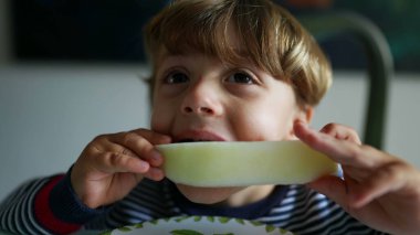 Karpuz meyvesi yiyen küçük çocuk sağlıklı atıştırmalıklar yiyor.