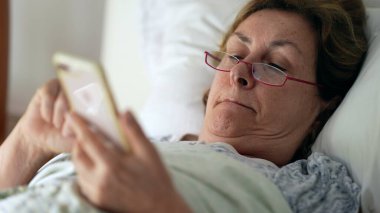 Sabah yatağında son sınıf öğrencisi telefona bakıyor.