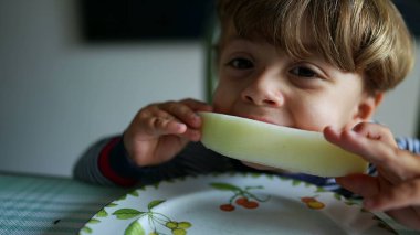 Karpuz meyvesi yiyen küçük çocuk sağlıklı atıştırmalıklar yiyor.