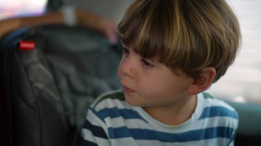 Arabanın arka koltuğunda oturan küçük çocuk yolda seyahat ediyordu. Otomobil aracının güvenlik koltuğundaki çocuk