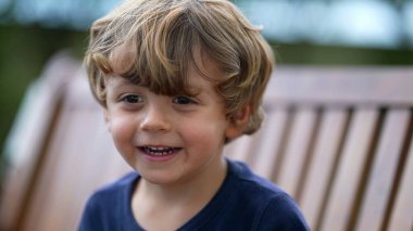 Küçük mutlu bir çocuğun portresi. Gülen ve gülümseyen küçük çocuk yüzü. Güzel, mutlu sarışın erkek çocuk.