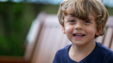 Küçük mutlu bir çocuğun portresi. Gülen ve gülümseyen küçük çocuk yüzü. Güzel, mutlu sarışın erkek çocuk.