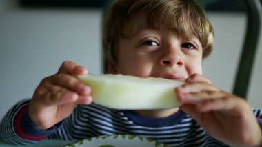 Karpuz meyvesi yiyen küçük çocuk sağlıklı atıştırmalıklar yiyor.