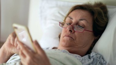 Sabah yatağında son sınıf öğrencisi telefona bakıyor.