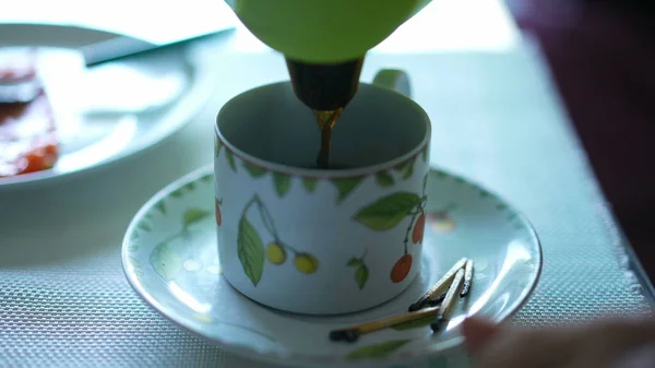 Serving coffee into cup closeup. Morning breakfast cafe. Liquid falling in slow motion