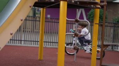 Çocuk parkta bisiklete biniyor. Samimi küçük çocuk dışarıda bisiklet sürüyor.