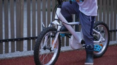 Çocuk bisiklet sürmeyi öğreniyor. Aktif bisikletçi çocuk bisiklet sürerken dengesini koruyor. Küçük çocuk egzersiz yapıyor.