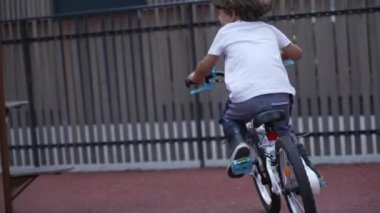 Bisikletli bir çocuk oyun alanında bisikletle kaza yapmış. Bisikletten düşen çocuk. Gerçek düşüş.