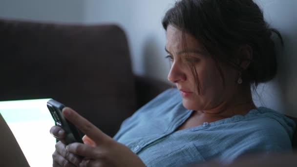 Mulher Preocupada Olhando Para Dispositivo Celular Com Emoção Preocupada Sentada — Vídeo de Stock