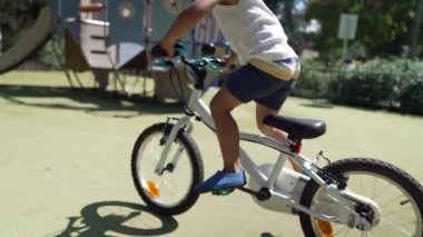 Dışarıda parkta bisiklete binen genç bir çocuk. Aktif çocuk egzersiz yapıyor.