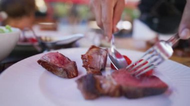 Öğle yemeğinde tabakta biftek servisi. Garson biftek servisi yapıyor. Restoran yemekleri.