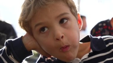 Kurabiye yiyen düşünceli küçük bir çocuk. Düşünceli çocuk bir lokma atıştırıyor. Sarışın çocuğun portresi.