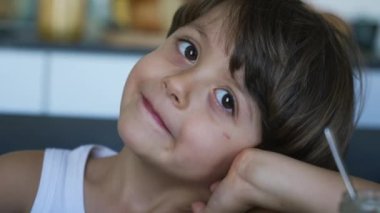 Şapşal, komik çocuk yakın çekim yüzü kafaya eliyle vuruyor. Sevimli çocuk el kol hareketi yapıyor.