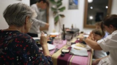 Ailenle yemek masasında büyükannenin arkası. Büyükbaba tatilde birlikte yemek yiyor.