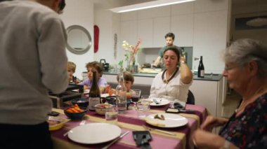 Aile yemek masasında. Tatil yemeği için bir araya toplanmış insanların gizli çekimleri.