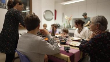 Aile yemek masasında. Tatil yemeği için bir araya toplanmış insanların gizli çekimleri.