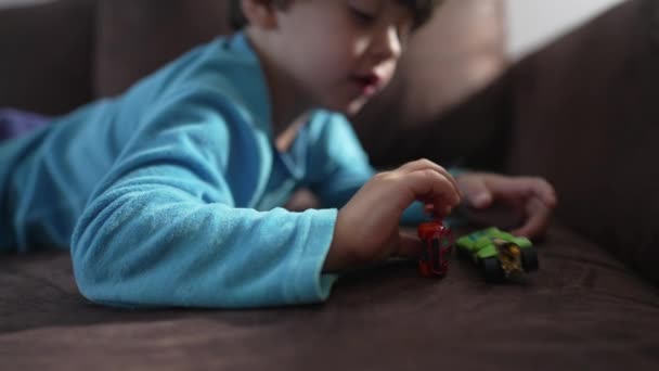 Ein Kleiner Junge Liegt Auf Der Couch Und Spielt Mit — Stockvideo