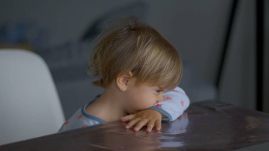 Bashful toddler watching cartoon in the morning in front of screen