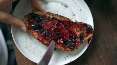 Child eating toast covered with jelly
