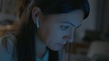 Woman working or studying at night in front of laptop computer