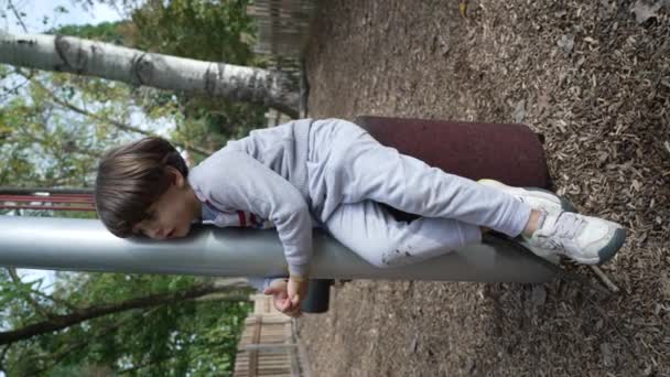 Один Маленький Хлопчик Сидить Дитячому Майданчику Парку Вертикальному Відео — стокове відео