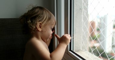 Çocuk pencereyi kapatıyor, bebek çocuk apartman penceresini kapatıyor