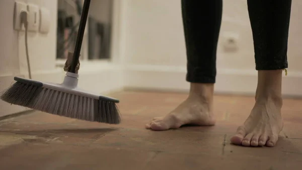 Person sweeping very dirty floor doing housework