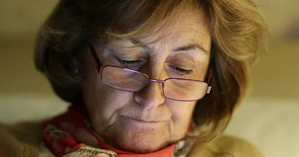 stock image Portrait of older woman wearing reading glasses looking at screen