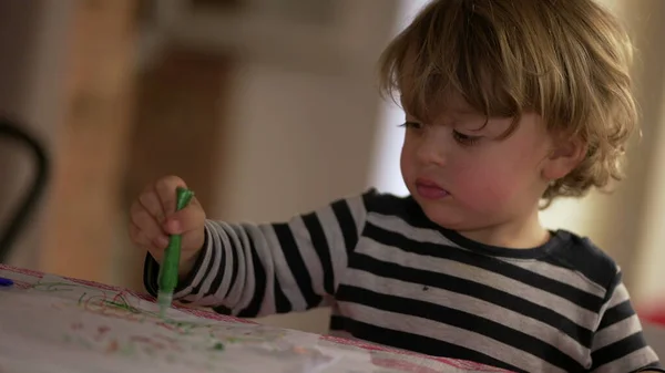 Baby with craft painting pen, toddler plays with green color